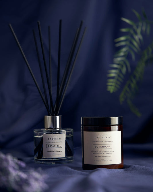 a couple of glass jars with brown liquid and a plant in the background